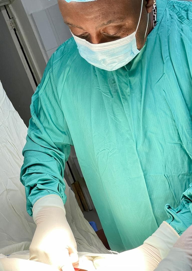 Dr. Garry René in surgical scrubs in the operating room at work, three decades of practice